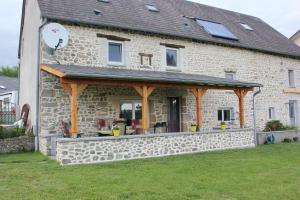 a large stone house with an outdoor deck at Maison le Barrage in Saint-Gervais-dʼAuvergne