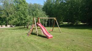a playground with a red slide in a park at Reimani Holiday House in Vanaveski