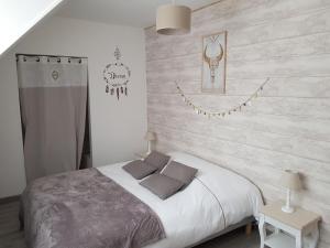 a bedroom with a bed and a wooden wall at Gîte les Hortensias in Marquise
