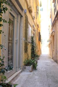 a narrow alley with a building and plants on it at NJ Corfu Liston Apartments in Corfu Town