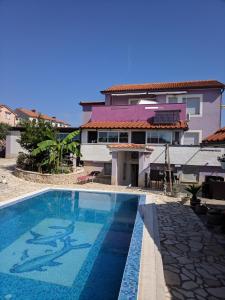 a swimming pool in front of a house at Villa Lory Krk in Krk