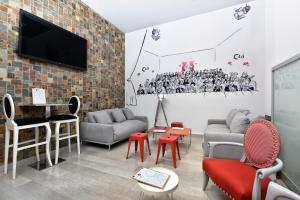uma sala de estar com mobiliário e uma televisão numa parede de tijolos em CLÁ Hotel - Boutique em Teruel