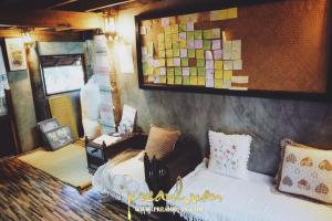a bedroom with a bed and a painting on the wall at Preanhuan Homestay in Mae On