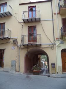 ein Gebäude mit zwei Balkonen und einer Tür mit Blumen in der Unterkunft CASA DELL'ARCO in Calatafimi