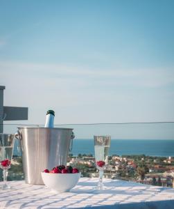 una mesa con copas de vino y un bol de fruta en Dempla Heights Villas, en Tavronitis