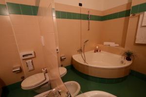 a bathroom with a tub and a toilet and a sink at Classic Hotel Tulipano in Terni