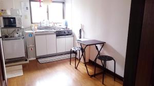 eine Küche mit einem Tisch und 2 Hockern in der Unterkunft Namio Apartment 201 in Tokio + 21 Fotos