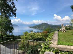 a statue of a lion on a hill overlooking a lake at La Casa nel Parco in Arona