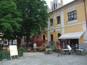 a group of tables and chairs in front of a building at Hotel Zvezda in Murska Sobota