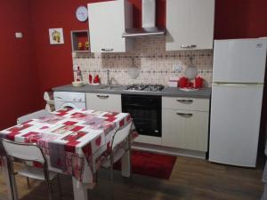 a kitchen with white appliances and a table with a christmas wrapping at Domus Mea in Trabia +38 photos