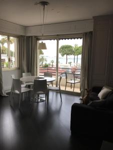 un soggiorno con divano, tavolo e sedie di Appartement Le Palais Des Iles a Cannes