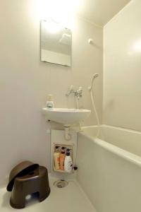 ein weißes Badezimmer mit Waschbecken und Badewanne in der Unterkunft Namio Apartment 201 in Tokio