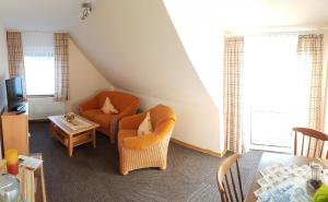 a living room with a chair and a table at Café Hausnordlicht - Ferienwohnung 2 in Dornum