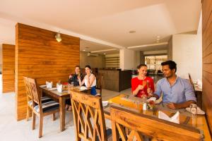 a group of people sitting at a table in a restaurant at The Fern Residency, Miramar in Panaji