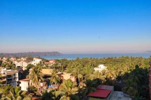 uitzicht op een stad met palmbomen en de oceaan bij The Fern Residency, Miramar in Panaji