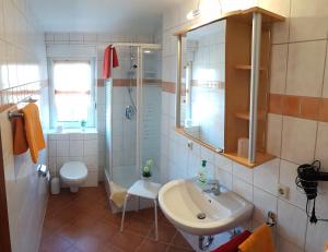 a bathroom with a sink and a shower and a toilet at Café Hausnordlicht - Ferienwohnung 2 in Dornum +11 photos