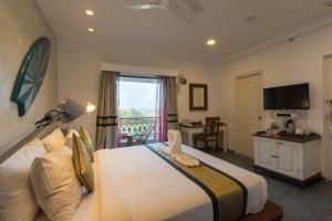 a bedroom with a bed with a stuffed animal on it at The Fern Residency, Miramar in Panaji