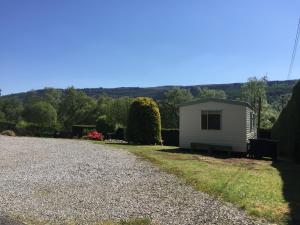 un pequeño edificio blanco al lado de un camino de grava en Forest View - Adults Only - Maximum 2 Guests en Drumnadrochit