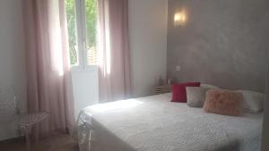 Schlafzimmer mit einem Bett mit roten Kissen und einem Fenster in der Unterkunft Pianotolinca in Moltifao