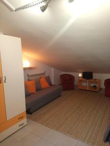 a living room with a couch with orange pillows at Villa Axa in Casal Palocco