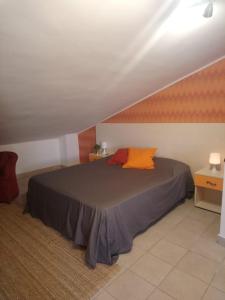 a bedroom with a bed with an orange pillow on it at Villa Axa in Casal Palocco