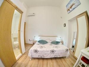a white bedroom with a bed and a bathroom at Luna in Dubrovnik