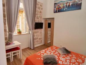 um pequeno quarto com uma cama e uma janela em Luna em Dubrovnik