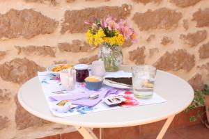 uma mesa com um prato de comida e um vaso de flores em B&B Il Falco e l'Ulivo em Rocca Massima