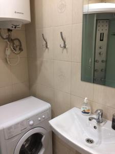 La salle de bains est pourvue d'un lave-linge et d'un lavabo. dans l'établissement Cozy apartment near the airport "Kyiv", à Kiev