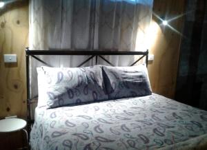 1 dormitorio con 1 cama con cabecero de metal y almohadas en Woodenbong Bed and Breakfast, en Woodenbong