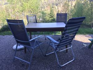 a picnic table with two chairs and a table and chairs at Titisee Haus Vogelnest in Titisee-Neustadt