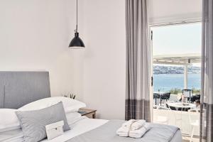 a hotel room with two beds and a window at Mykonos Princess Hotel in Agios Stefanos