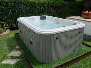 a hot tub sitting on the grass in a yard at Residence Aurora in Albenga