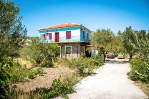 a house on a dirt road with cars parked at Diamanti Molivos Studios & Apartments in Mithymna