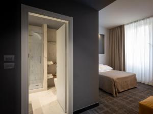 ジェノヴァにあるHNN Luxury Suitesのベッドルーム1室(ベッド1台、バスルーム付)