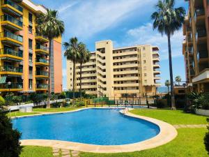 a swimming pool in front of two tall buildings at Luxury Apartment Bajondillo Beachfront in Torremolinos