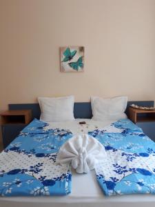 a blue and white bed with a towel on it at Blue House - Синята къща in Obzor
