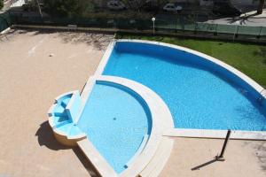 een uitzicht op een leeg zwembad met een stoel bij Edificio Fragata A in Armação de Pêra