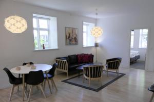 a living room with a couch and a table and chairs at Dragør Hotel & Apartments in Dragør