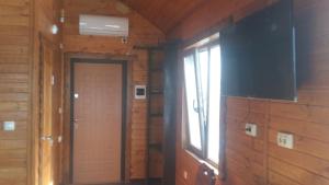 a room with a door and a window and a television at Villa Mango in Vylkove