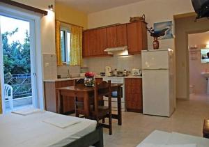 a kitchen with a table and a white refrigerator at Areti & Maria Apartments in Gythio