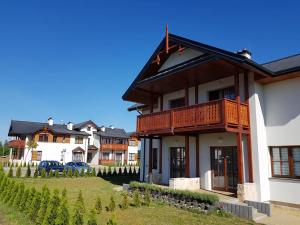 a house with a balcony on the side of it at Poduszka Apartamenty Zdrojowe in Nałęczów