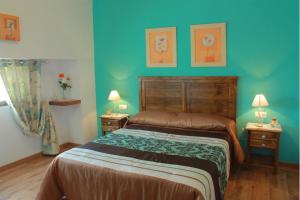 a bedroom with a bed and two tables with lamps at La Fabrica De Juan in La Joya