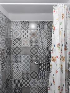 a bathroom with black and white tiles on the wall at Casa Porumbacu 295 in Porumbacu de Sus +90 photos