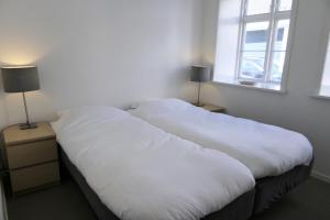 two white beds in a room with a window at Dragør Hotel & Apartments in Dragør