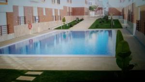 uma grande piscina azul num edifício em Cabanas2 em Cabanas de Tavira