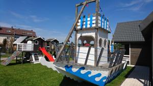 un parque infantil con una estructura de juegos de barcos piratas en Domeczki Blaneczki, en Wicie