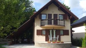 a house with a balcony with two chairs on it at Holiday Home Adna in Bihać