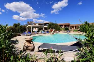 a swimming pool with a table and chairs in front of a house at Agriturismo Salmarina in Abbiadori