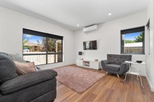 a living room with a couch and two chairs at Rosewater Townhouses Dromana in Dromana